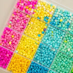Organized craft bead kit in rainbow colors sorted into compartmented tray for jewelry making