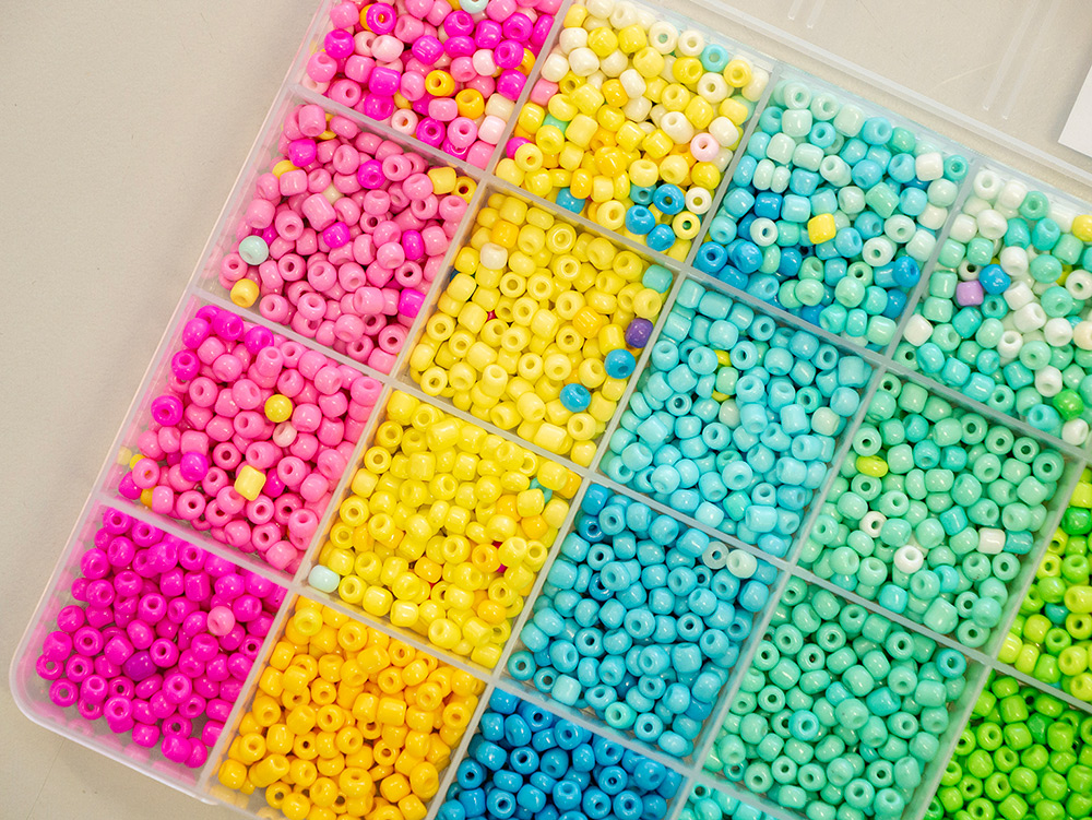 Organized craft bead kit in rainbow colors sorted into compartmented tray for jewelry making