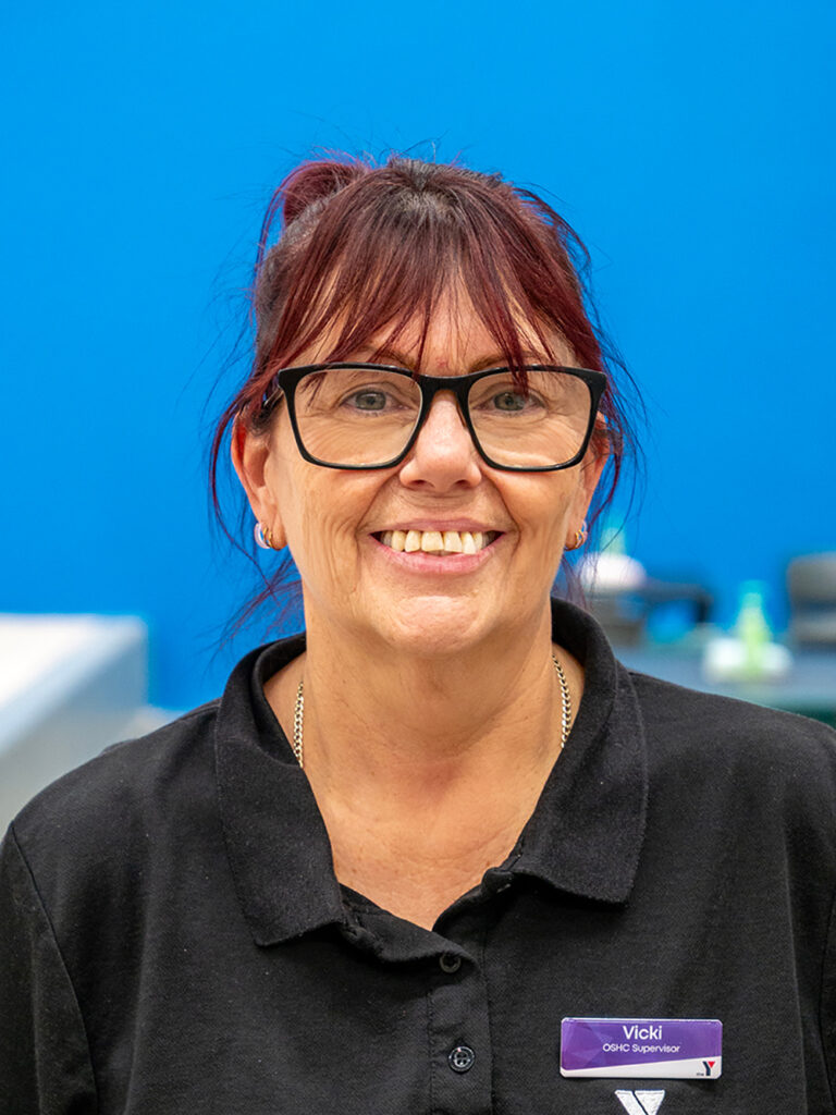 Smiling Y WA OSHC Supervisor in a black polo shirt against a blue background.