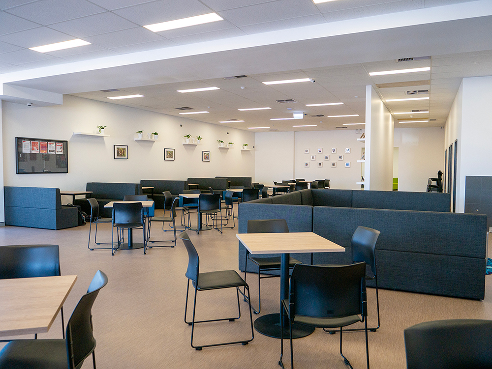 Large and spacious classroom with tables, chairs and couches at the Y School