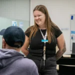 A teacher from the Y School Mirrabooka Junior Campus smiling down at another person