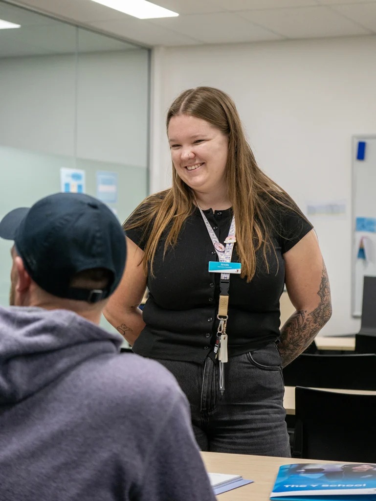 A teacher from the Y School Mirrabooka Junior Campus smiling down at another person