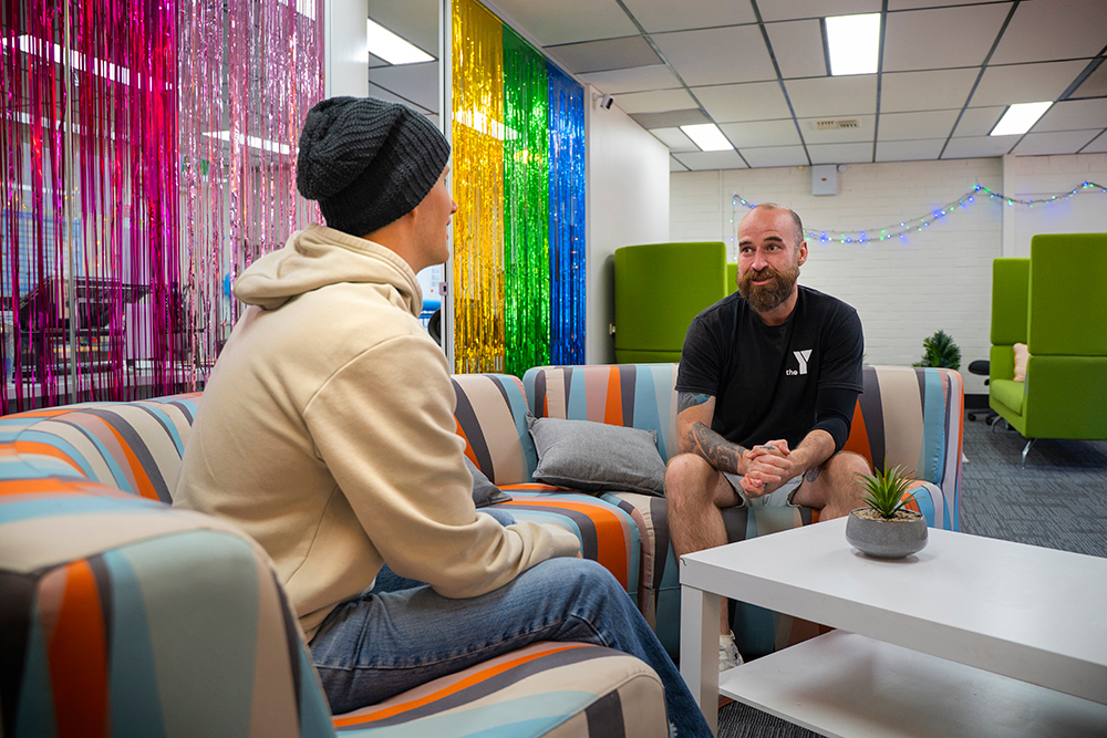 Youth worker engaging with a young person in a private room at a youth centre