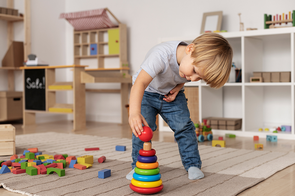 Child playing with wooden blocks on carpet in play room