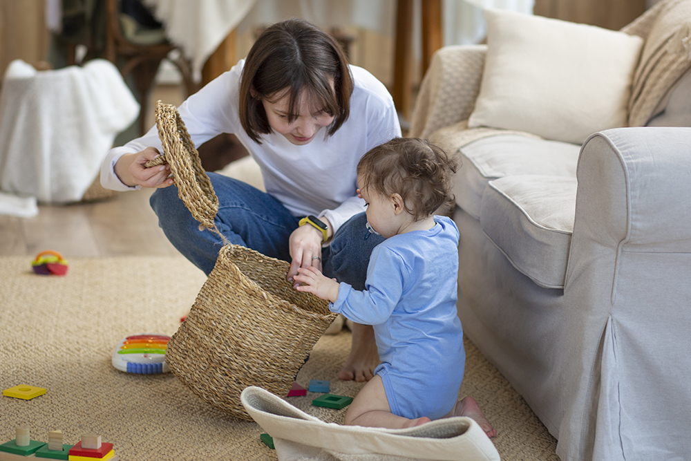 Mother and chilld looking in a wicker basket with toys