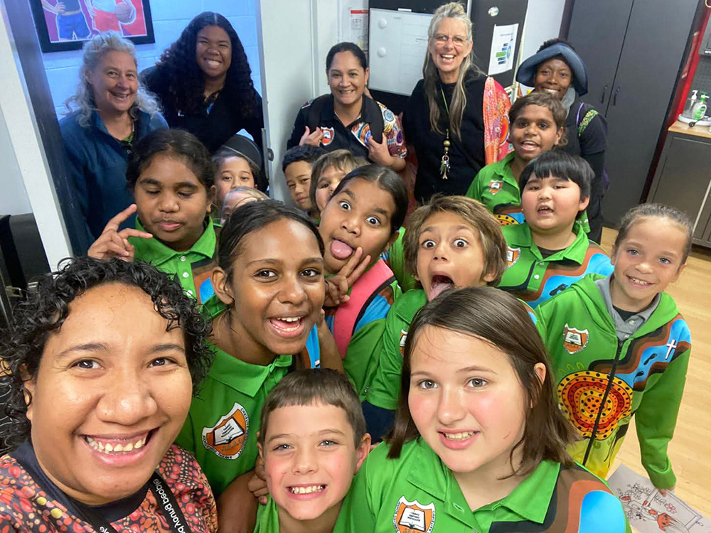 Large group of children, young people and staff smiling at the camera during fun activity
