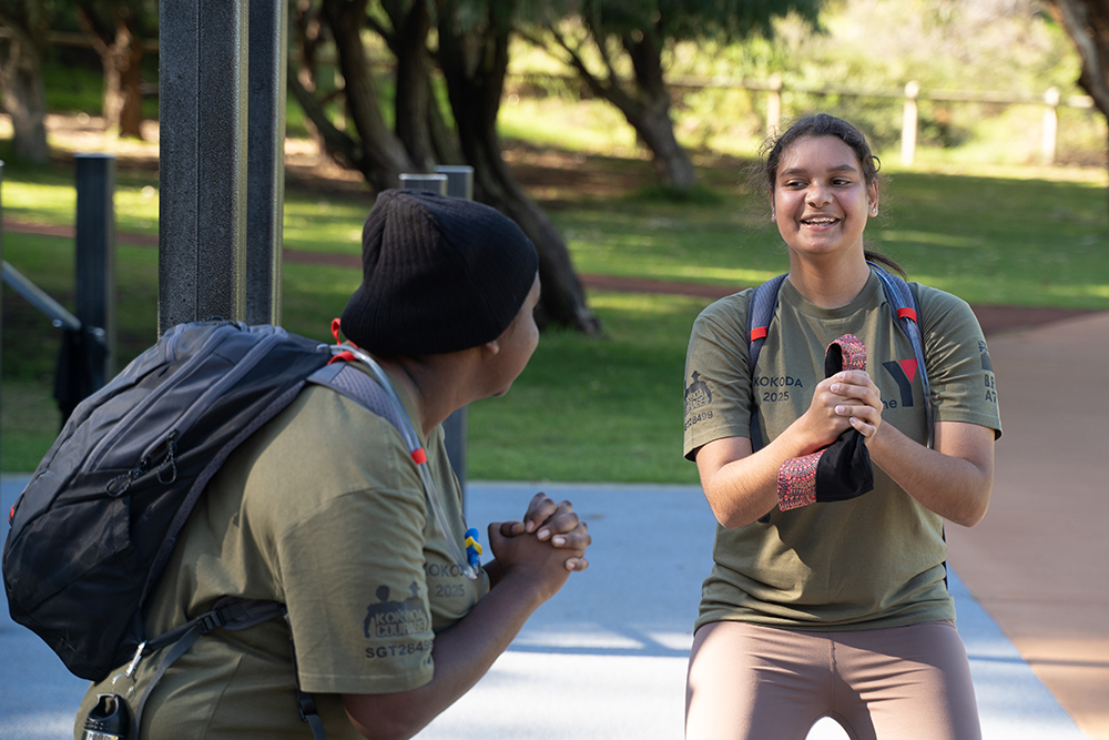 Two first nations young people happily exercising together outside wearing Y WA tshirts