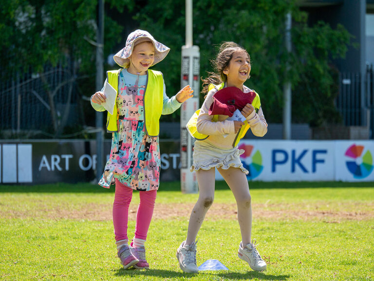 Two children laughing together during Coles Healthy Kicks sports activity at West Leederville OSHC School Holiday Program