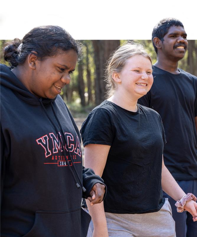Group of three diverse young people, including two First Nations young people walking together and smiling.