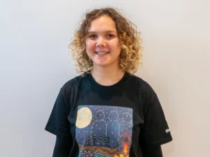 Young woman from the Y School proudly wearing a NAIDOC tshirt she designed for NAIDOC week