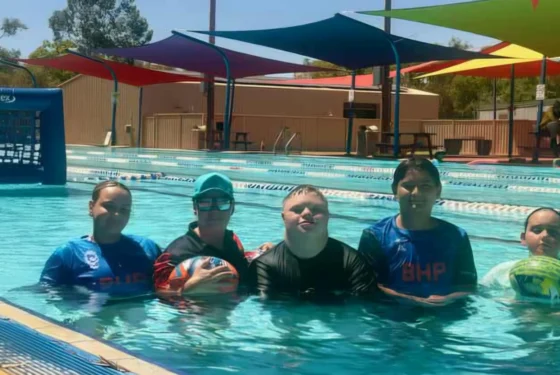 Children swimming in an outdoor pool during a water sports activity