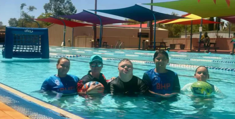 Children swimming in an outdoor pool during a water sports activity